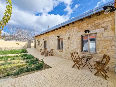 a stone house with chairs and a patio at Andre Marie Stonewood Retreat in Limassol