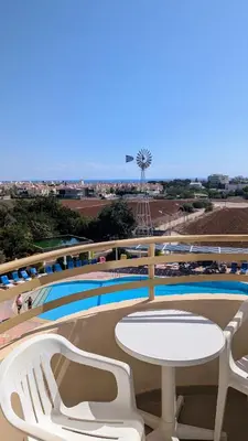 a table and chairs in front of a swimming pool at Kama Lifestyle Modern apt with sea view in Protaras