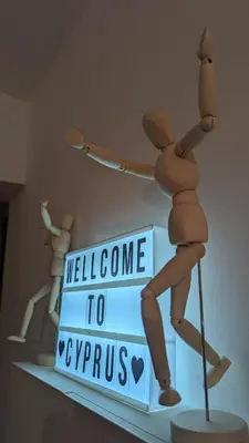 a wooden mannequin holding a welcome to cyprus sign at Kama Lifestyle Modern apt with sea view in Protaras