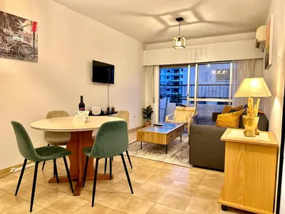 a living room with a table and chairs at Sea and Lake Breeze 1BR Apt in Larnaka