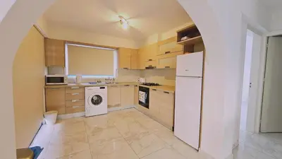 a kitchen with a white refrigerator and a dishwasher at STAY Chrisoula Beach Garden in Voroklini