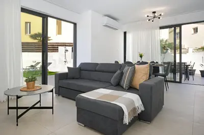 a living room with a couch and a table at Villa Vitalia - 3 En-suite Beds with Private Pool in Paralimni