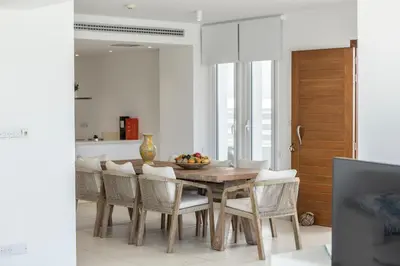 a dining room with a wooden table and chairs at Protaras Sirina Seafront Paradise in Protaras