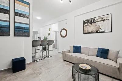 a living room with a couch and a table at FatCow Beach Apartment in Larnaka