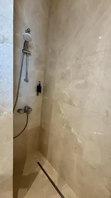 a shower with a shower head in a bathroom at Oxford House Apt by TrulyCyprus in Limassol