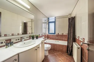 a bathroom with a sink and a toilet and a mirror at Ayia Napa Sycamore SeaView in Ayia Napa