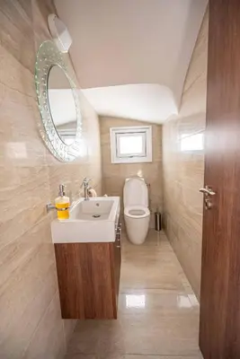 a bathroom with a sink and a toilet and a mirror at Hubstay - Blue Harmony Villa in Protaras - 5 min Walk to the Beach in Paralimni