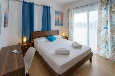 a bedroom with a bed and a desk and a table at Hubstay - Blue Harmony Villa in Protaras - 5 min Walk to the Beach in Paralimni