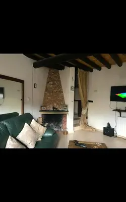 a living room with a green couch and a fireplace at Clover Cottage in Limassol