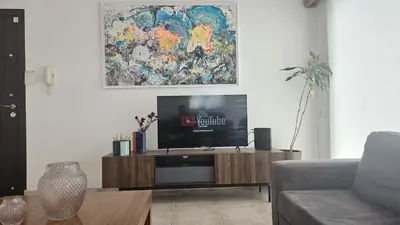 a living room with a television on a wooden entertainment center at STAY Uptown Apartment in Engomi