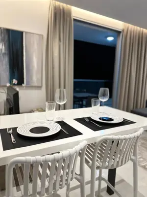 a dining table with two plates and wine glasses on it at Joanna & Arya Central Engomi Apts in Nicosia