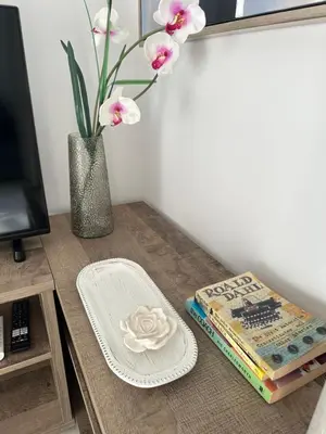 a table with a vase of flowers and a book at Joanna & Arya Central Engomi Apts in Nicosia