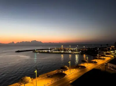 a large body of water with a pier at night at Sea View 1BR With Pool Access in Larnaka