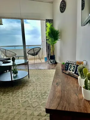 a living room with a table and a view of the ocean at Sea View 1BR With Pool Access in Larnaka