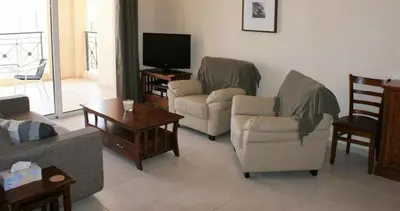 a living room with two couches and a tv at Mazotos Panoramic Village in Mazotos
