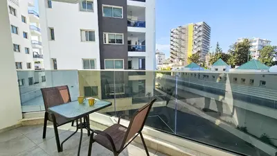 a table and two chairs on a balcony with a window at Modern Wellness Escape Apartment with Optional Health Transformation Retreat in Larnaka