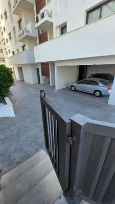 a car parked in a parking lot next to a building at Modern Wellness Escape Apartment with Optional Health Transformation Retreat in Larnaka