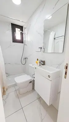 a white bathroom with a sink and a toilet at Modern Wellness Escape Apartment with Optional Health Transformation Retreat in Larnaka