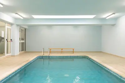 a swimming pool with a bench in a room at Obv 5201 in Pyla