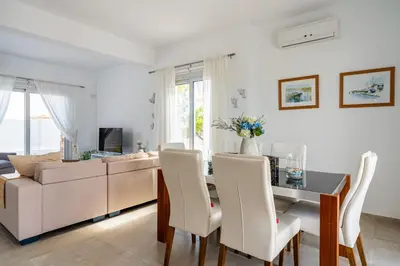 a living room with a table and a couch at Corali Villa in Pernera Protaras in Paralimni
