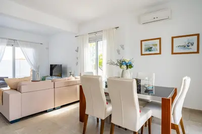 a living room with a table and a couch at Corali Villa in Pernera Protaras in Paralimni