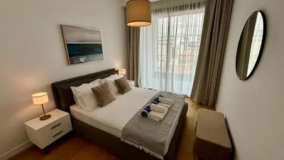 a bedroom with a bed and a large window at Bali Residence Apt by TrulyCyprus in Limassol