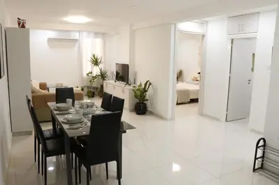 a dining room and living room with a table and chairs at Spacious Apartment, NEAR PINIKOUDES BEACH in Larnaka