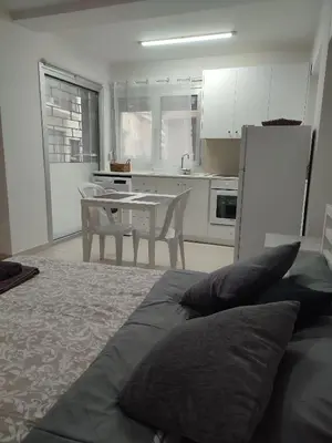 a bedroom with a bed and a kitchen with a table at Alkinoos Studio in Nicosia