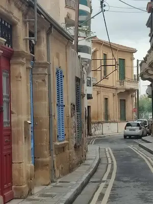 a street with buildings and a car parked on the street at Alkinoos Studio in Nicosia