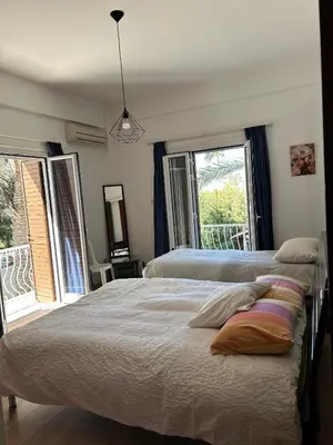 a bedroom with two beds and a large window at Bougainvillea in Nicosia