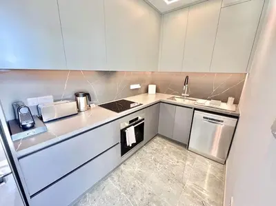 a small kitchen with white cabinets and a sink at V-Premium Brand New Central flat in Limassol