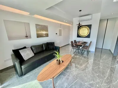 a living room with a black couch and a table at V-Premium Brand New Central flat in Limassol