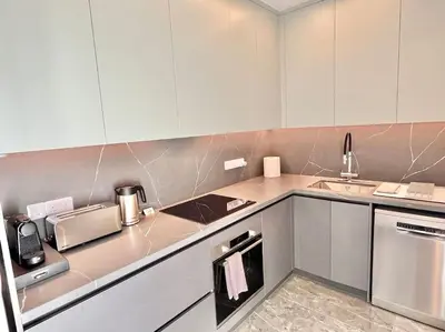 a kitchen with white cabinets and a counter top at V-Premium Brand New Central flat in Limassol