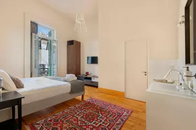 a bedroom with a bed and a sink and a bathroom at Klokkari Stays - Cozy Stay City Center By Platform 357 in Nicosia