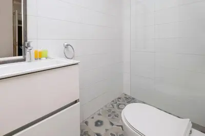 a white bathroom with a toilet and a mirror at Klokkari Stays - Cozy Stay City Center By Platform 357 in Nicosia