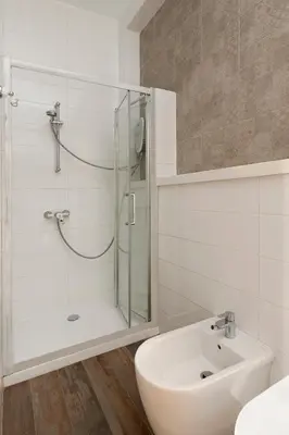 a white bathroom with a shower and a sink at Klokkari Stays - Cozy Stay City Center By Platform 357 in Nicosia