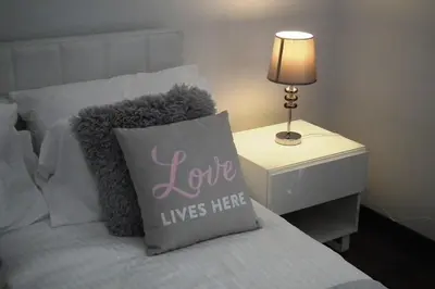 a bed with a pillow with the words love lives here at Villa Anthea-beach-private pool in Meneou