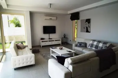 a living room with a couch and a table at Villa Anthea-beach-private pool in Meneou