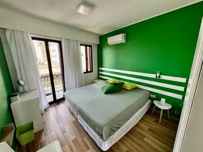 a green bedroom with a bed and a green wall at It can't be more central Larnaca in Larnaka