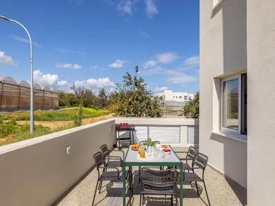 a patio with a table and chairs on a balcony at Mythical Blue Apartment 004 in Protaras