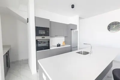 a white kitchen with a counter and a sink at Aqua Pearl Villas in Protaras