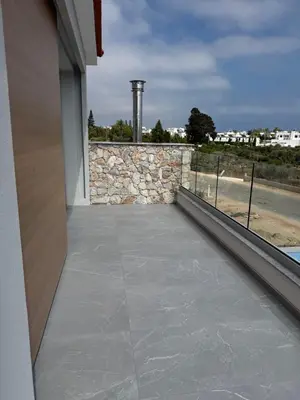 a balcony of a house with a stone wall at Theo luxury Napa villa in Ayia Napa