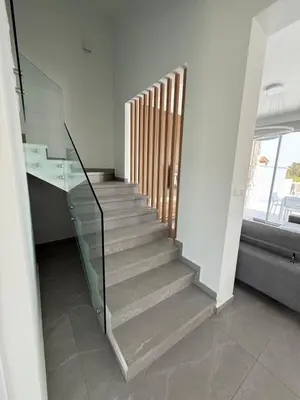 a staircase in a house with a glass railing at Theo luxury Napa villa in Ayia Napa