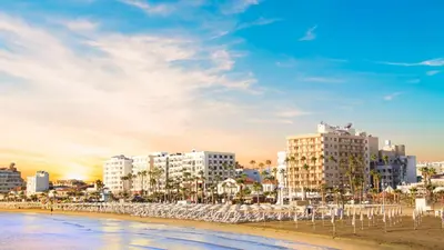a view of a beach with buildings and the ocean at Kolonaki Seaview 1BDR Finikoudes in Larnaka