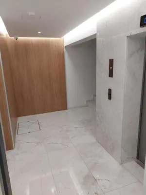 a room with a white marble floor and a wooden door at Seafront City Center Studio in Limassol