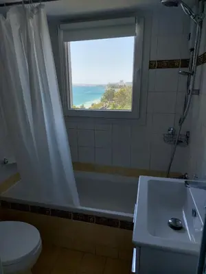 a bathroom with a tub and a sink and a window at Seafront City Center Studio in Limassol