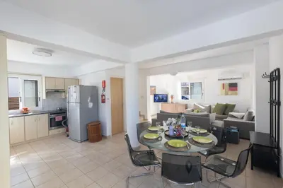 a kitchen and a living room with a table and chairs at Protaras Blue River Villa BR26 in Protaras