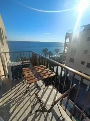 a table and chairs on a balcony with the ocean at Danit apartmnt by the sea in Zygi