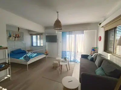 a living room with a couch and a baby crib at Danit apartmnt by the sea in Zygi