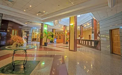 a lobby with a table in the middle of a building at Tsokkos Gardens Hotel in Protaras